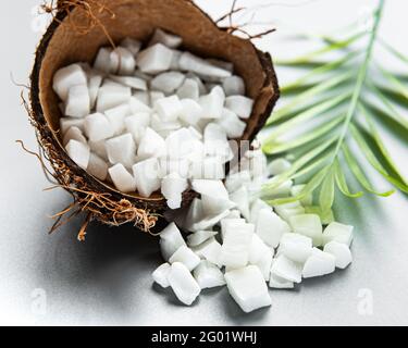 Dried sweet coconut cubes  in bowl on white background. Stock Photo