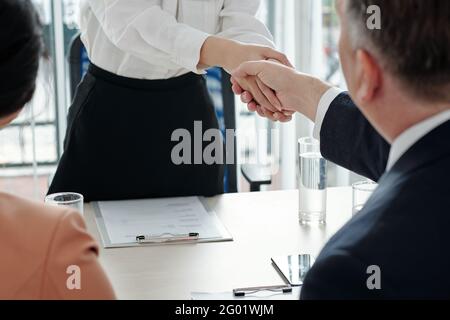 Female applicant shaking hands of HR manager and company CEO after successful meeting Stock Photo