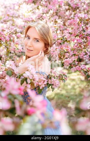 Portrait of a girl in a blooming rose garden in summer. Stock Photo