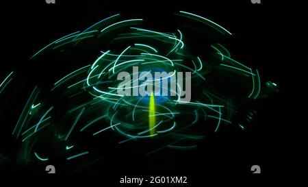 Blue circle surrounded by green light streaks Stock Photo