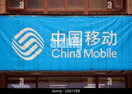 China mobile logo above a mobile phone store in China. Writing in both Chinese and English. Stock Photo