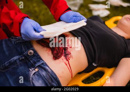 Paramedic giving help to an injured person after accident. First aid training. Stock Photo