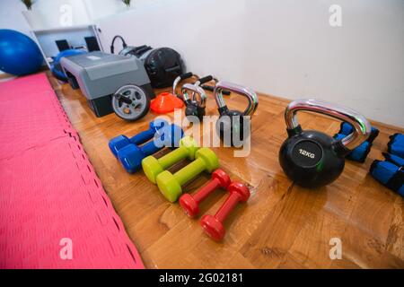 Colorful kettlebells in a row in a gym. Fitness or bodybuilding concept background. Stock Photo