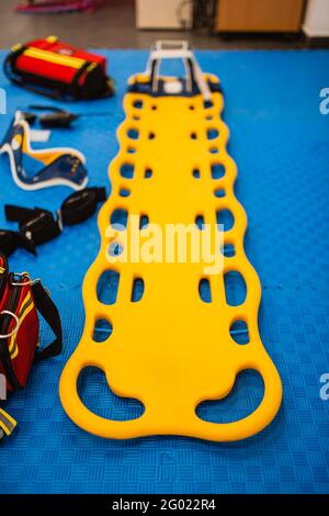 Yellow first aid stretcher on a blue background. First aid equipment Stock Photo