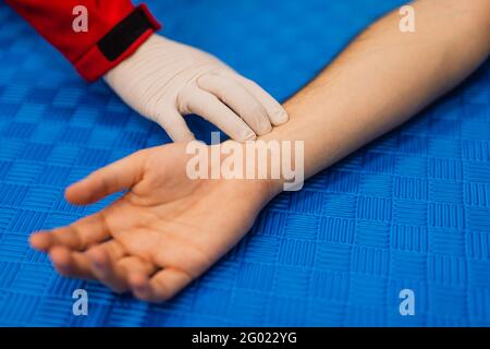 Doctor is checking patience's pulse by fingers, medical checking on table. Stock Photo
