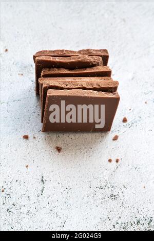 Milk chocolate chunks on light background Stock Photo