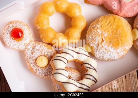 Different type of donuts set, sweet donuts in a paper donut box dessert snack food. Stock Photo