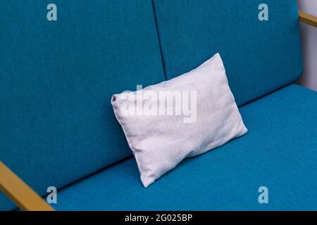 Blank white pillow on a blue sofa. Close-Up Of Pillow on a couch. Stock Photo