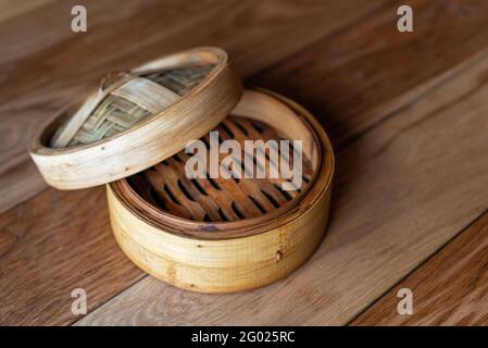 Bamboo steamer set, chinese kitchenware on wooden table, top view. Empty traditional asian bamboo steamer for steamed dumplings Dim Sums. Stock Photo