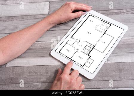 Apartment plan concept shown on a tablet used by a woman Stock Photo