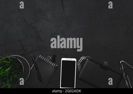 Business accessories on graphite background. Business, distance work, self-study concept. Top view, flat lay, low key. Stock Photo