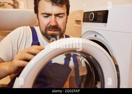 Do-it-yourselfer or plumber repairs defective clothes dryer in the laundry room Stock Photo