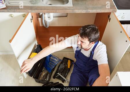 Plumber or plumber installing or assembling a sink in the kitchen Stock Photo