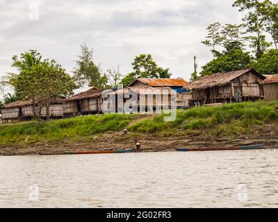 West Papua, Indonesia - January,  2015: Wooden houses on the stilt in the jungle on the bank of the Brazza River. Asia Stock Photo