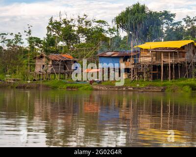 West Papua, Indonesia - January,  2015: Wooden houses on the stilt in the jungle on the bank of the Brazza River. Asia Stock Photo