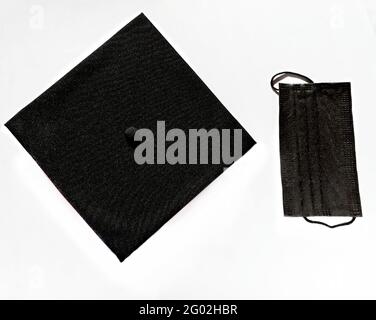 Graduate black cap and protective face mask on white background, protection from the virus while studying, getting a diploma in a new reality, new nor Stock Photo