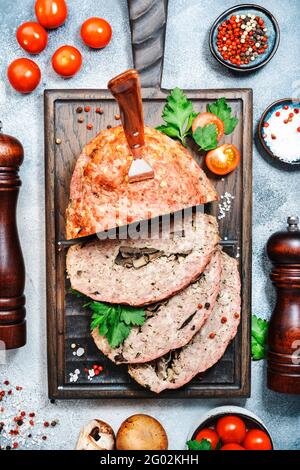 Meatloaf with mashrooms, classic american food with baked pork beef minced meat on cutting board. Top view Stock Photo