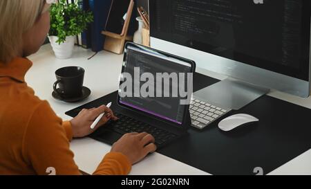 Cropped shot of young woman programmer working on project in software development company. Stock Photo