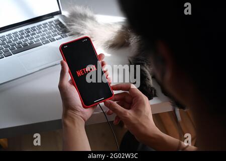 Chiang Mai ,Thailand - May 13, 2021 : Man holding iPhone 11 Pro Max with Netflix logo. Netflix is global provider of streaming movies and series. Stock Photo