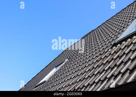 Roof window in velux style with black roof tiles Stock Photo