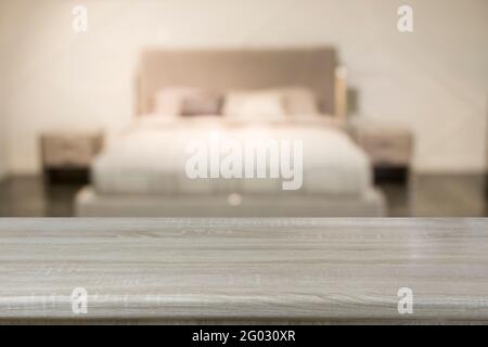 Empty wooden board and blurred modern bedroom with house interior as background. Abstract pattern for display your home products. Stock Photo