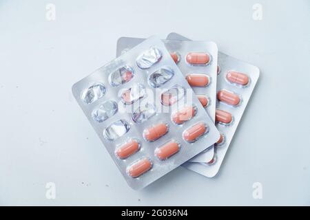 Tablets in a blister on a white background. On top of the half-empty used blister Stock Photo