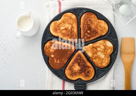 kes in shape of breakfast hearts in the frying pan with ingredients for cooking. Healthy breakfast or snack. Breakfast for Valentines Day.Top view cop Stock Photo