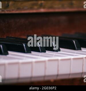 A fragment of the keyboard of an old piano. Black and white keys of an old piano. Selective Focus Stock Photo