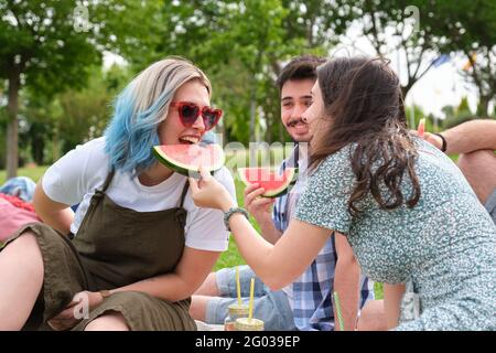Happy group of friends giving watermelon to each other. Summer day. Stock Photo