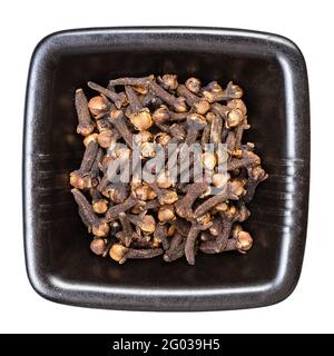 top view of whole dried cloves in black bowl isolated on white background Stock Photo