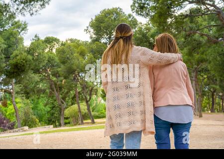 Happy family walking in nature park .Mother and her daughter having fun and relaxing outdoors. Stock Photo