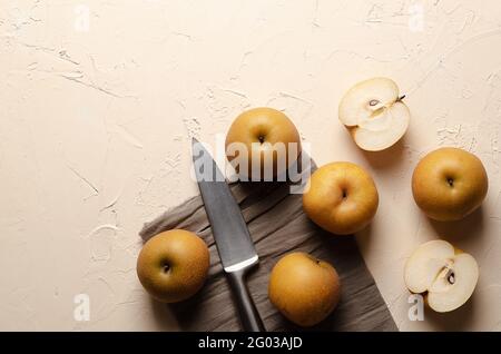 Asian pears with a silver knife on a light background. Stock Photo