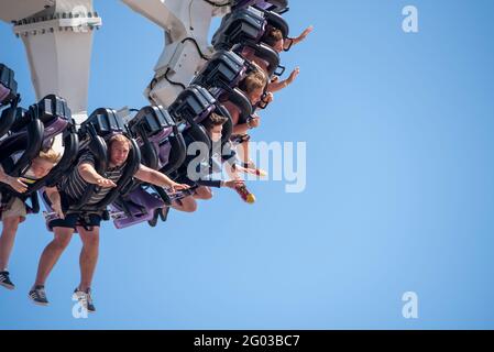 Southend on Sea, Essex, UK. 31st May, 2021. The warm sunny weather has attracted people to the seaside town on the Bank Holiday Monday. Thrill riders on the Axis thrill ride in Adventure Island pleasure park Stock Photo