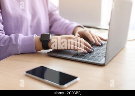 Happy woman sitting at desk reading text message Stock Photo