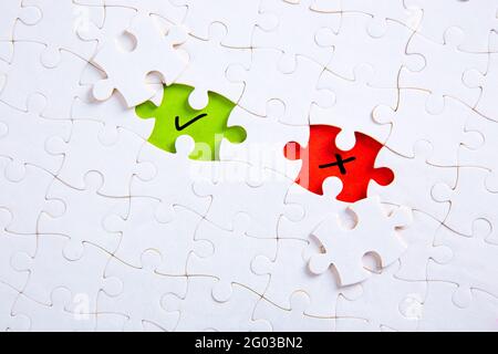 Missing puzzle pieces with check mark and cross symbols. Stock Photo