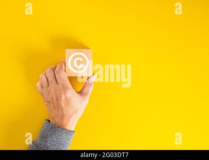 Businessman hand holding a copyright symbol. Property rights and brand patent protection in business concept. Stock Photo