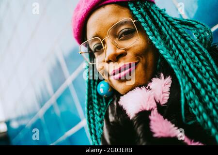 Portrait of smiling braided hair woman wearing eyeglasses and pink lipstick Stock Photo