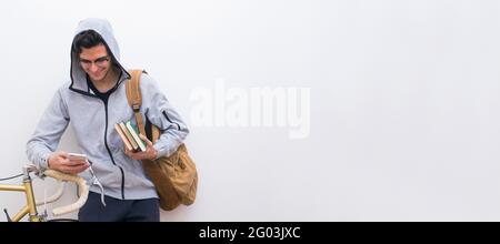 student with cellphone and bicycle on white wall background Stock Photo