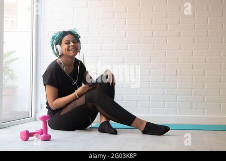 woman doing sports and listening to music with headphones and smartphone Stock Photo