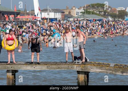 Southend on Sea, Essex, UK. 31st May, 2021. The warm sunny weather has attracted people to the seaside town on the Bank Holiday Monday. The beaches  are busy and teens are using a jetty to jump into the sea. Male drinking Stock Photo