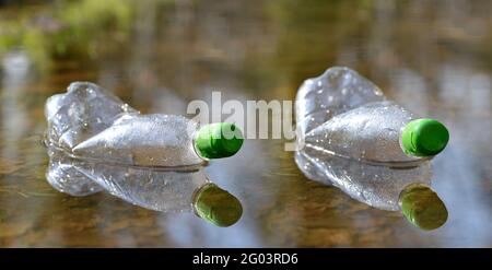 Plastic bottles floating in puddle of water. Pollution garbage in forest. Concept of nature conservation. Stock Photo