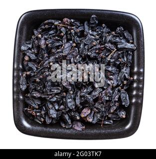 top view of dried black barberry fruits in black bowl isolated on white background Stock Photo