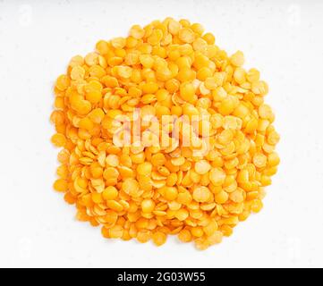 top view of pile of raw split red lentils close up on gray ceramic plate Stock Photo