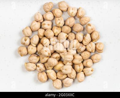 top view of pile of raw dried chickpea seeds close up on gray ceramic plate Stock Photo
