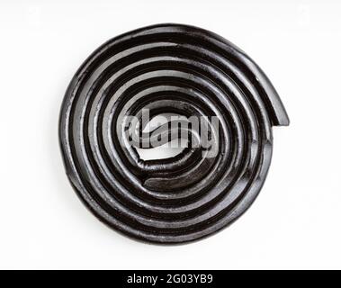 top view of spiral from black liquorice candy on white plate Stock Photo