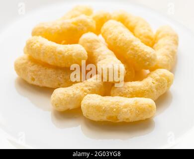 pile of corn puffs on white plate cllose up Stock Photo