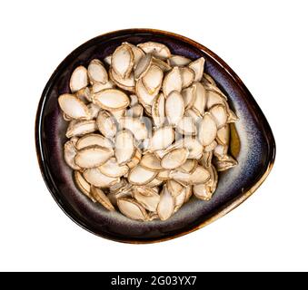 top view of whole pumpkin seeds in ceramic bowl isolated on white background Stock Photo
