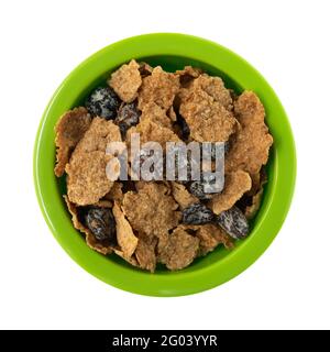 Top view of generic bran flakes with raisins in a green bowl isolated on a white background. Stock Photo