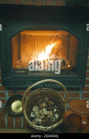 mushrooms in a basket and chimney with fire in an old retro view Stock Photo