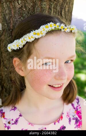 Nine year-old girl with a daisy chain on her head in the shape of a crown. UK. (123) Stock Photo